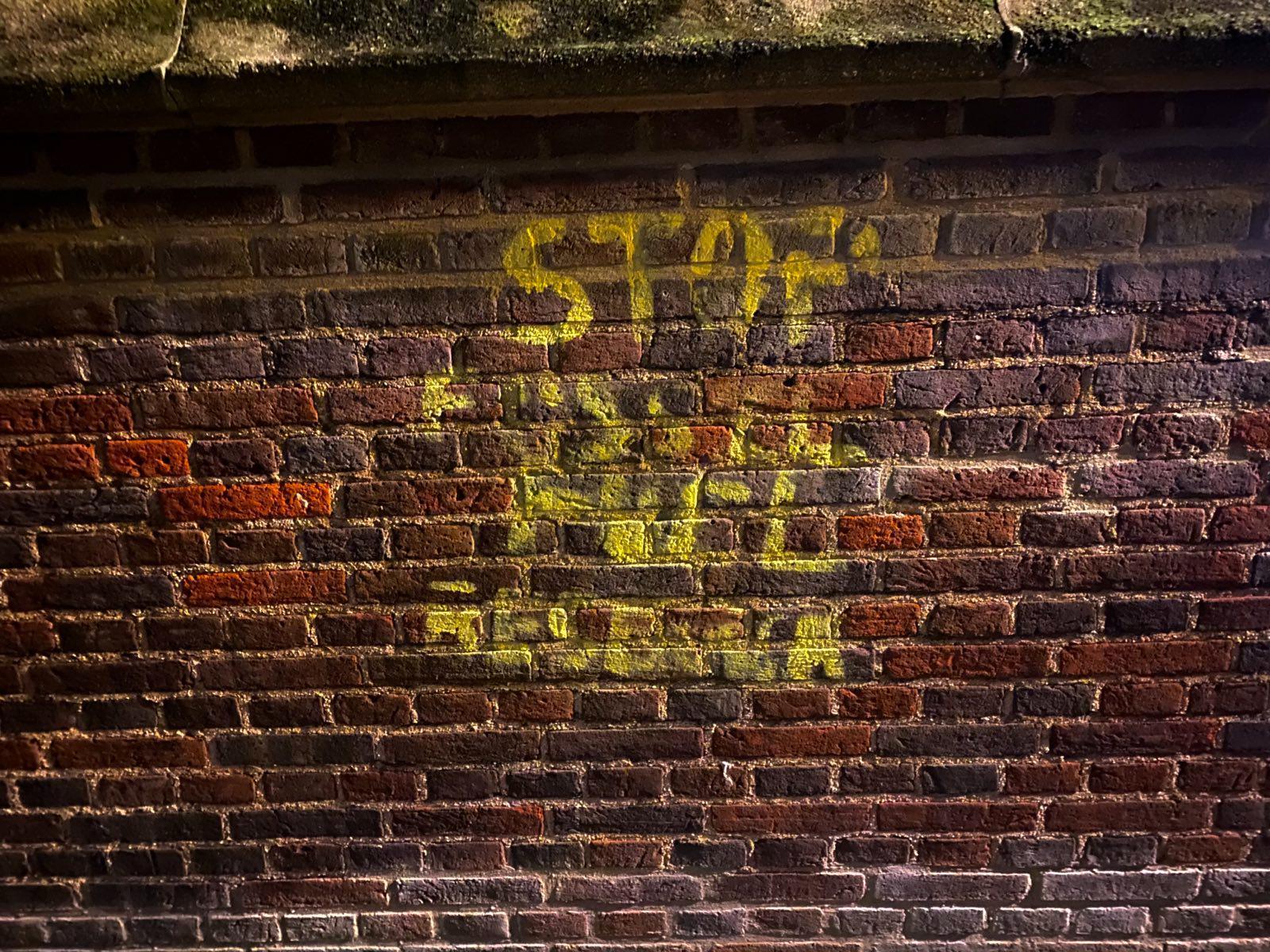 The wall of the Oxford Institute for Energy Studies has been stencilled with the worlds "STOP FOSSIL FUEL RESEARCH" in yellow.