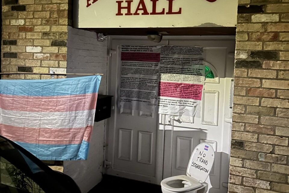 The same scene at night, with the trans flag flying at full mast!